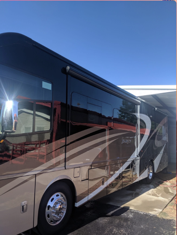 Detailed brown Journey motorhome shining under a covered bay