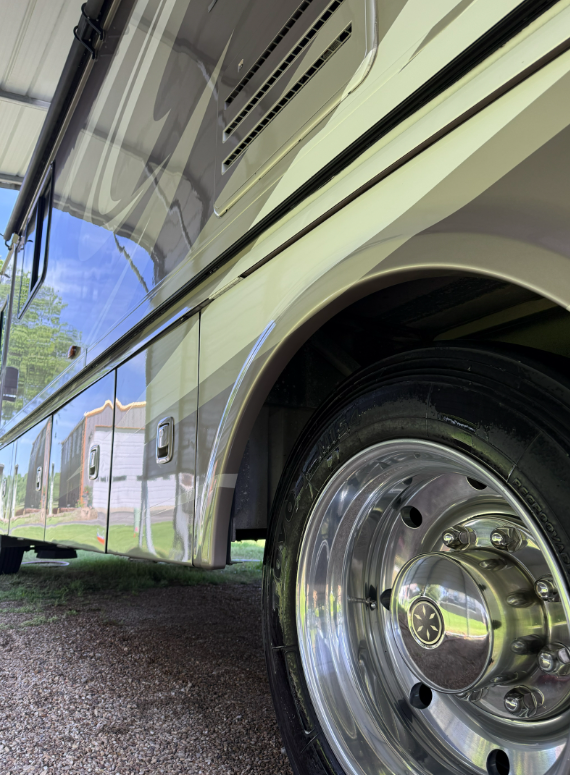Close-up of a polished RV wheel and mirror-finish body panel