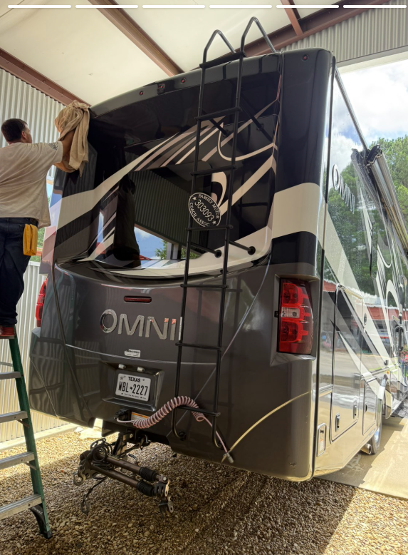 Hand drying the rear of a motorhome under a covered bay